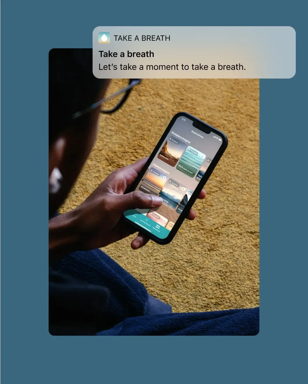 Person holding a phone with a Take a Breath reminder notification prompting a breathing exercise