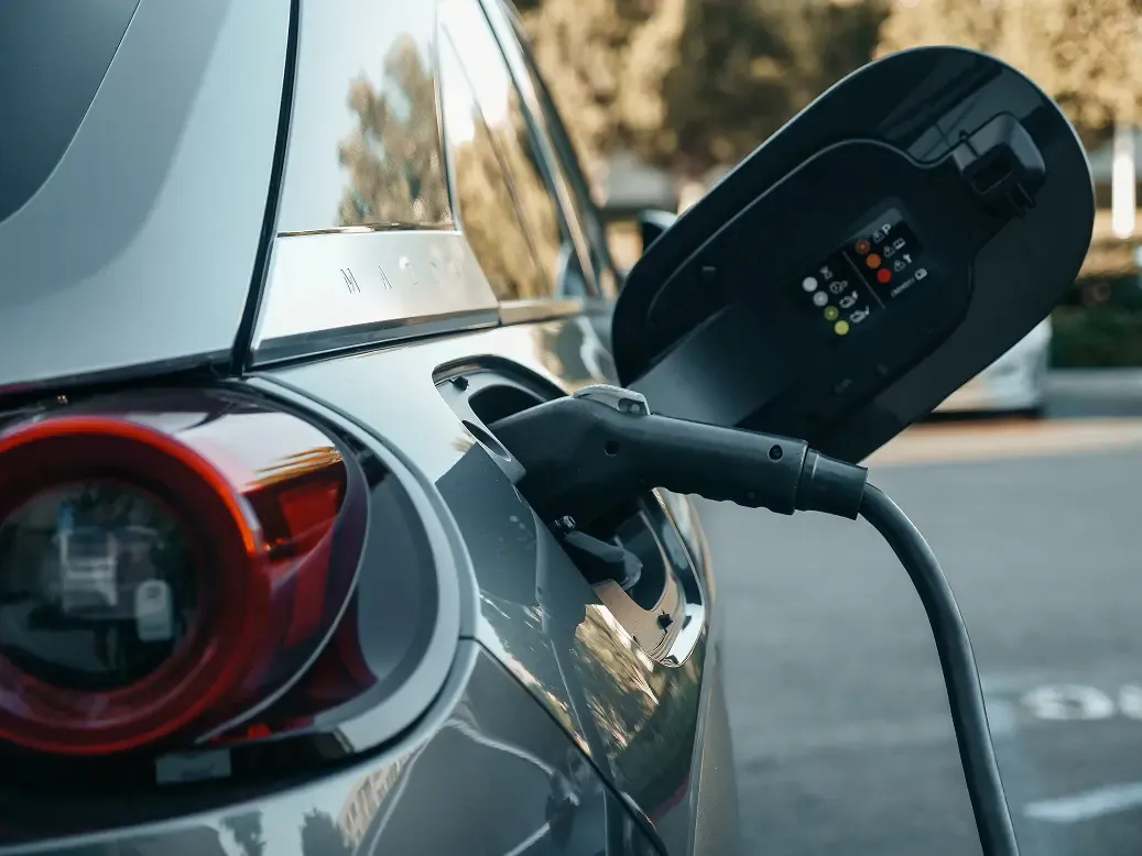 An electric vehicle plugged into a public charging station