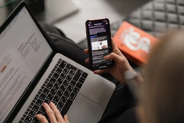 Person using mobile and laptop for digital compliance workflows