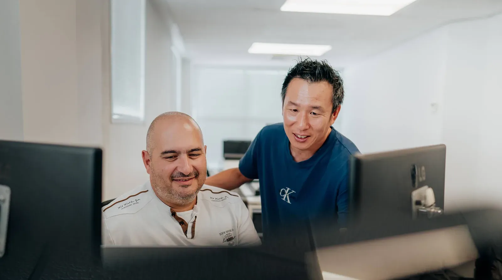 Two Putti team members reviewing a build together on screen