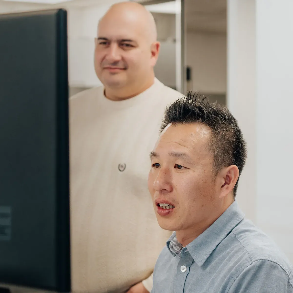 Two Putti team members reviewing a web platform build on screen